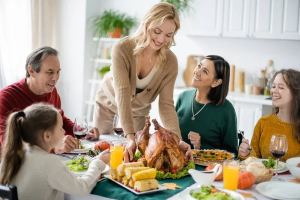 Mosolygó Többnemzetiségű Család Nézi Ízletes Pulyka Hálaadás Vacsora Otthon — Stock Fotó