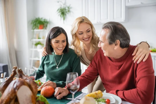 Позитивная Женщина Обнимает Многонациональных Родителей Возле Ужина Честь Дня Благодарения — стоковое фото
