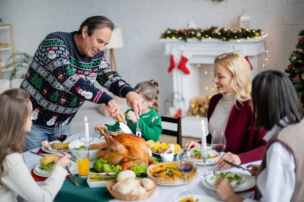 Senior Schneidet Gebratenen Truthahn Der Nähe Der Familie Beim Weihnachtsessen — Stockfoto