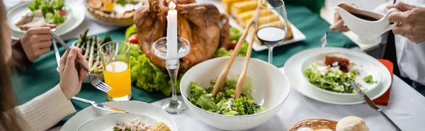 感謝祭のダイナーの近くの家族の部分的なビューおいしい七面鳥と野菜のサラダ バナー — ストック写真
