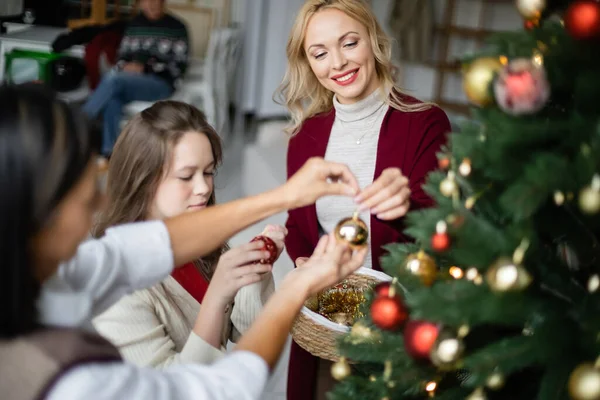 Lycklig Kvinna Dekorera Julgran Med Dotter Och Suddig Multiracial Mor — Stockfoto