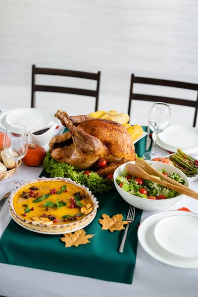新鮮な野菜サラダの近くにロースト七面鳥と感謝祭のディナーのテーブルの上のカボチャのパイ — ストック写真