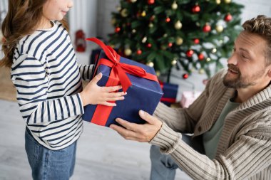 Çocuğun babasına yılbaşı hediyesi evde bulanık bir Noel ağacı. 