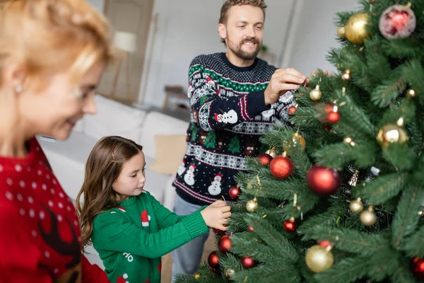 Flicka Varm Tröja Dekorera Julgran Med Föräldrar Hemma — Stockfoto