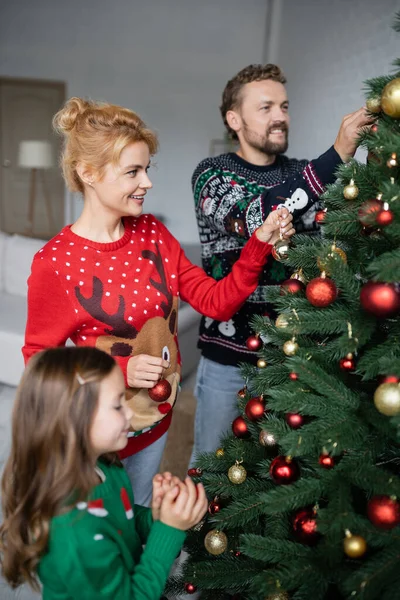 Mulher Positiva Suéter Decorando Árvore Natal Com Família Casa — Fotografia de Stock