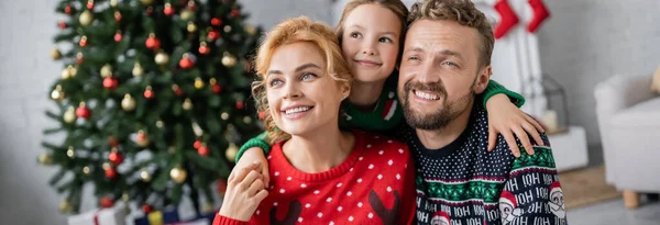 Criança Abraçando Pais Sorridentes Camisolas Quentes Durante Celebração Natal Casa — Fotografia de Stock