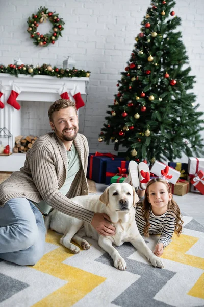 Padre Hijo Acariciando Labrador Cerca Borroso Árbol Navidad Regalos Casa — Foto de Stock