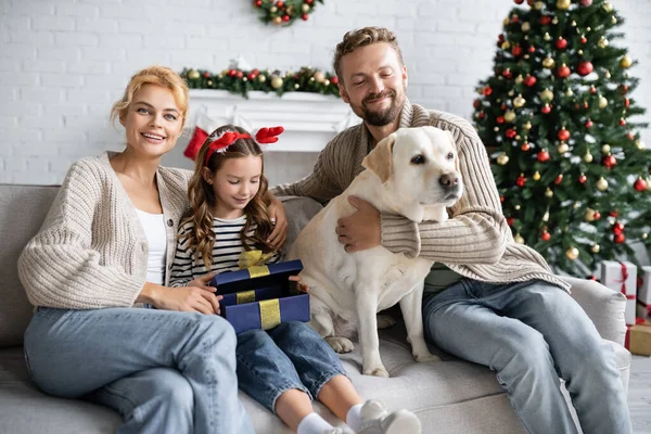 Kız Noel Hediyesini Ailesinin Yanında Açıyor Labrador Kanepenin Üzerinde — Stok fotoğraf