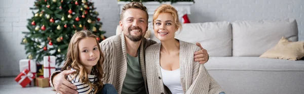 Homem Sorridente Abraçando Esposa Filha Durante Natal Casa Banner — Fotografia de Stock