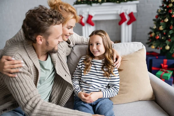 Mulher Sorridente Abraçando Filha Marido Sofá Durante Natal Casa — Fotografia de Stock