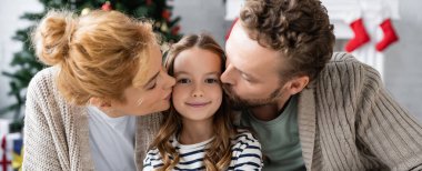 Parents kissing happy preadolescent girl during new year at home, banner   clipart