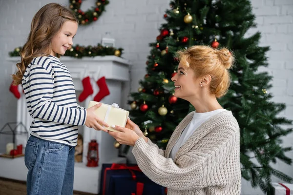 Glimlachende Dochter Geeft Nieuwjaarscadeau Aan Moeder Buurt Van Kerstboom Woonkamer — Stockfoto