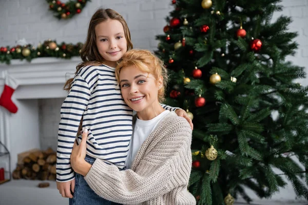 Sorrindo Mãe Malha Cardigan Abraçando Filha Perto Árvore Natal Casa — Fotografia de Stock