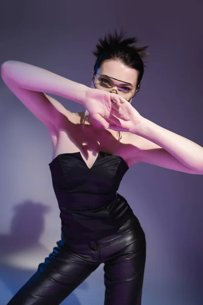 Брюнетка Жінка Чорному Корсеті Шкіряні Штани Затемнюють Обличчя Руками Фіолетовому — стокове фото