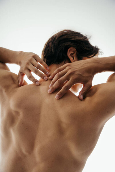 назад вид человека без рубашки с мускулистым телом позирует изолированы на белом