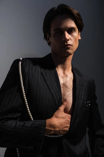 Man Trendy Suit Pearls Looking Camera While Posing Dark Grey — Stock Photo, Image