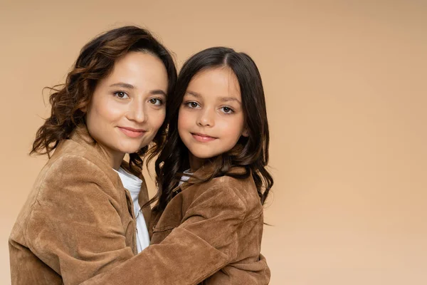 Moeder Dochter Stijlvolle Suède Jassen Glimlachen Camera Terwijl Knuffelen Geïsoleerd — Stockfoto