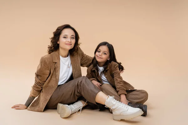 Happy Woman Brown Jacket Trendy Boots Embracing Daughter While Sitting — Stock Photo, Image