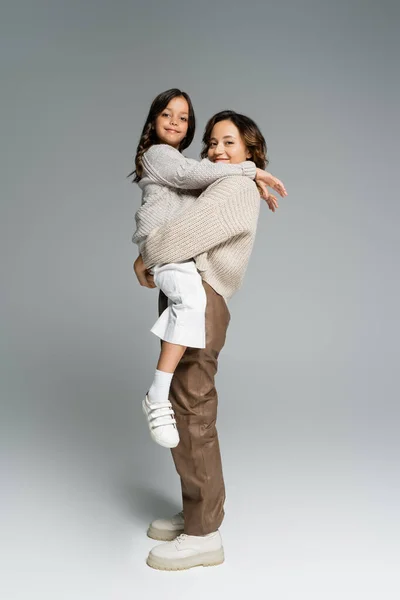 Feliz Moda Mujer Sosteniendo Sonriente Hija Las Manos Mientras Mira — Foto de Stock