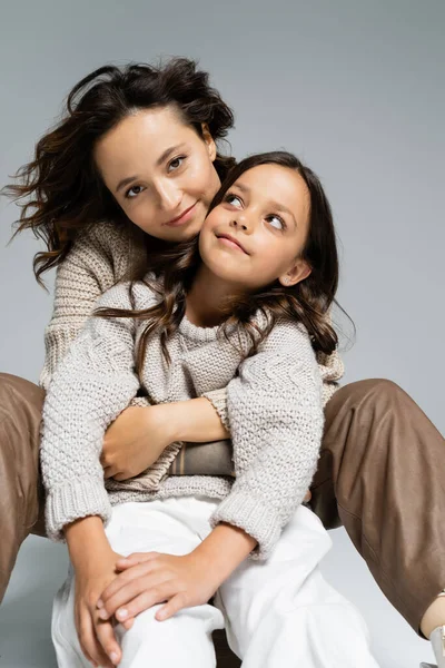 Mujer Elegante Feliz Mirando Cámara Mientras Abraza Hija Sobre Fondo — Foto de Stock