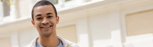 Jovem e feliz homem afro-americano sorrindo na cidade urbana, banner — Fotografia de Stock