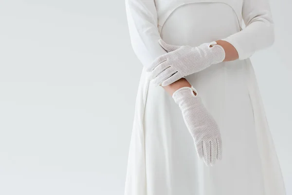 Обрезанный вид невесты в перчатках и белом платье изолированы на сером — стоковое фото
