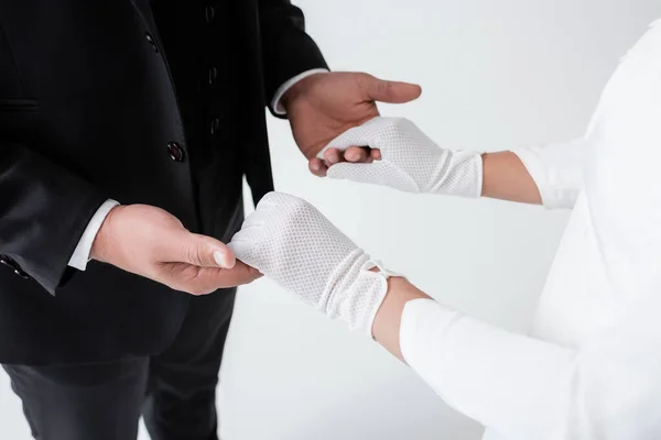 Vue recadrée de l'homme et de la femme en gants tenant les mains isolées sur gris — Photo de stock