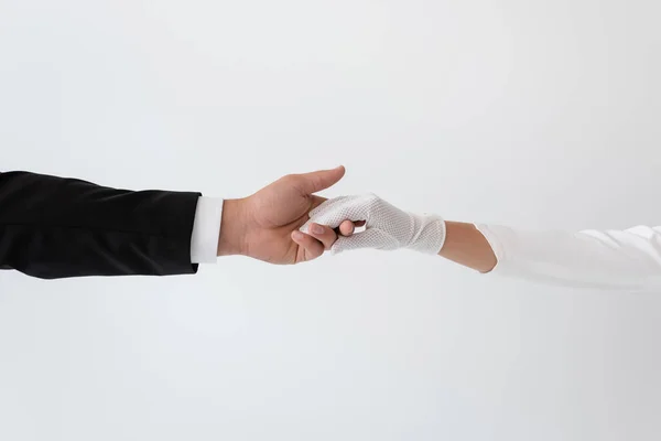 Cropped view of groom and bride holding hands isolated on grey — Stock Photo