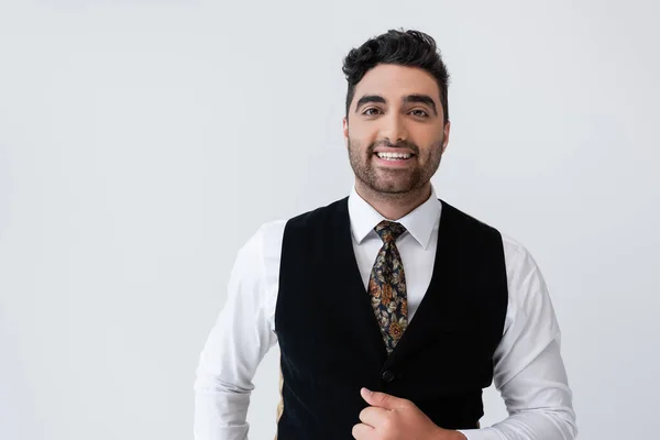 Happy muslim man in vest looking at camera isolated on grey — Stock Photo