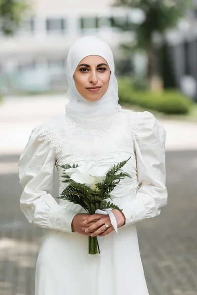 Muslim bride with diamond ring on finger holding wedding bouquet — Stock Photo
