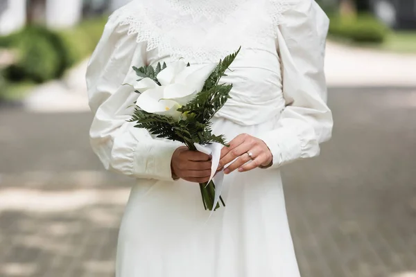 Vista recortada de la novia con anillo de diamante en el dedo celebración de ramo de boda - foto de stock