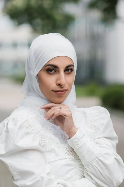 Retrato de la novia musulmana en hijab con anillo de diamantes en el dedo mirando a la cámara - foto de stock