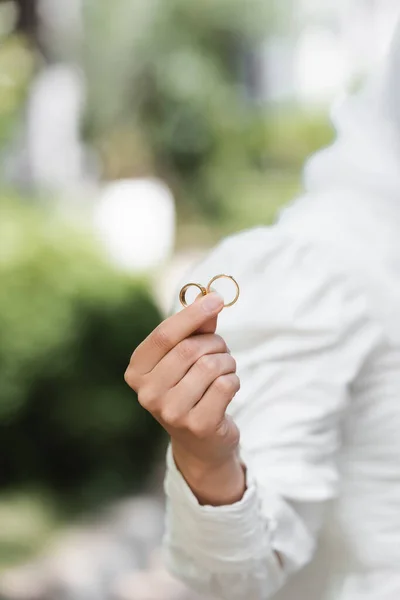 Cropped view of bride holding wedding golden rings in hand — Stock Photo