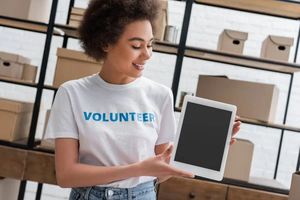 Lächelnde Afroamerikanerin mit digitalem Tablet mit leerem Bildschirm im Spendezentrum — Stockfoto