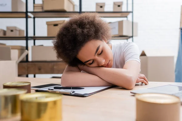 Exhausted african american woman sleeping at workplace in volunteer center — Stockfoto