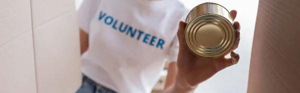 Bottom view of cropped african american woman holding canned food, banner — Stock Photo