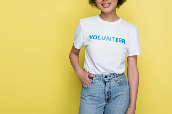 Partial view of african american volunteer holding hand in pocket of jeans isolated on yellow — Stock Photo