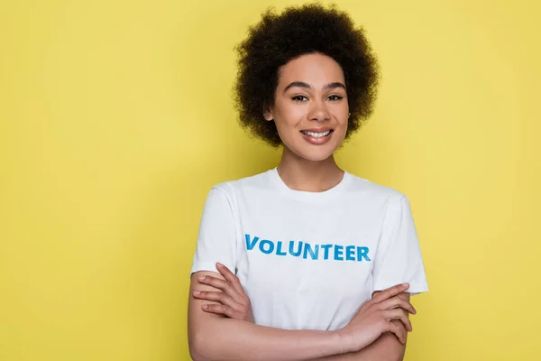 Happy african american woman in t-shirt with volunteer lettering isolated on yellow — Foto stock