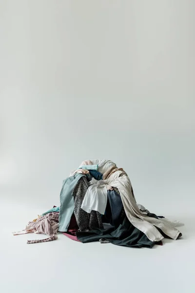 Grande pilha de roupas diferentes no fundo cinza — Fotografia de Stock