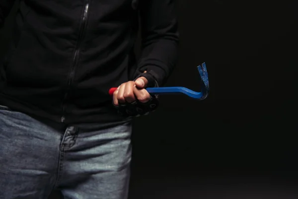 Cropped view of african american hooligan holding crowbar tool isolated on black — Stockfoto