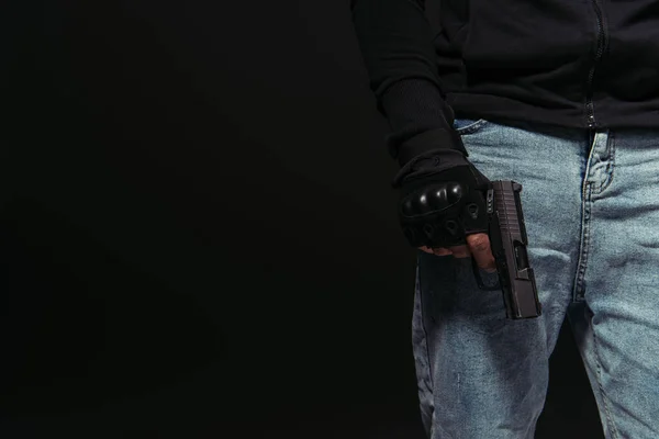 Vista ritagliata del teppista afroamericano che tiene la pistola isolata sul nero — Foto stock
