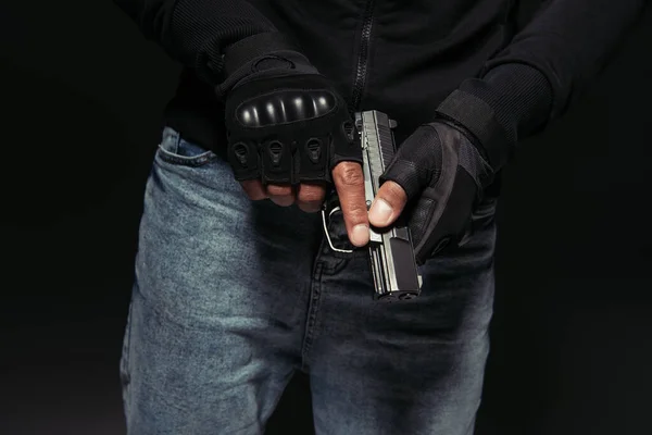 Cropped view of african american bandit in gloves holding gun isolated on black — Stock Photo