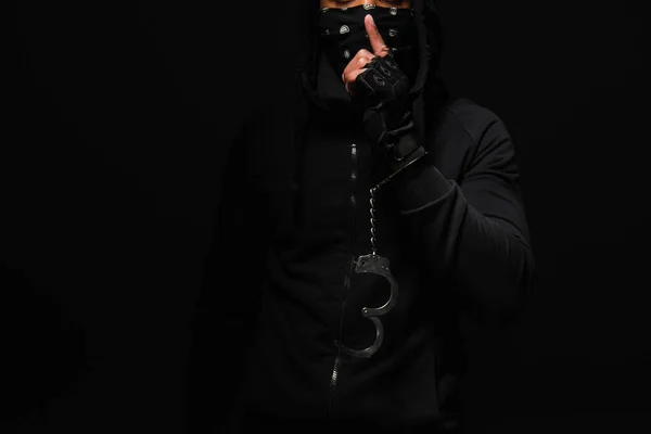 Cropped view of african american hooligan in handcuff showing secret gesture isolated on black — Foto stock