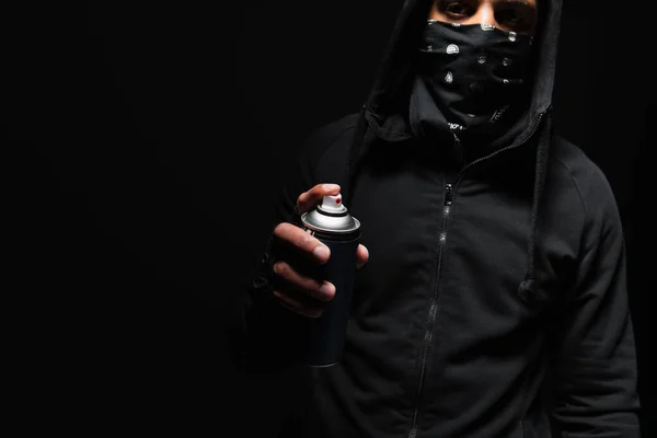 Cropped view of african american vandal with mask on face holding spray paint isolated on black — Stockfoto