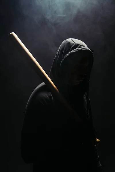 Silhouette of bandit holding baseball bat on black background with smoke — Stock Photo