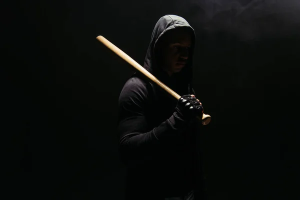 Silhouette of african american hooligan holding baseball bat isolated on black — Photo de stock