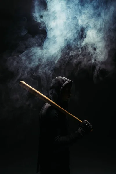 Silhouette of bandit with wooden baseball bat on black background with smoke — Foto stock
