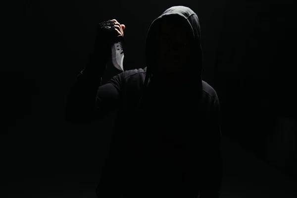 Silhouette of bandit holding knife isolated on black — Foto stock