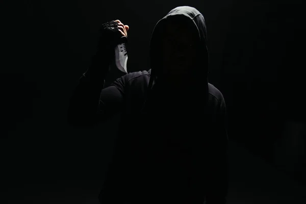 Silhouette of bandit holding knife isolated on black — Fotografia de Stock