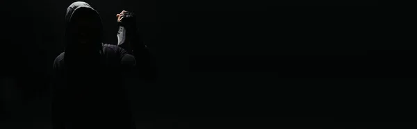 Силуэт хулигана с ножом изолирован на черном с копировальным пространством, баннер — стоковое фото